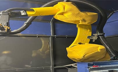 A yellow robotic plasma-cutting arm in its protective cover