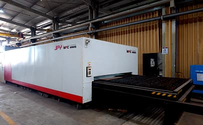 An enclosed CNC laser-cutting machine on the workshop floor