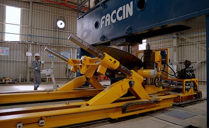 A dishing press forming a vessel head, a technician beside it