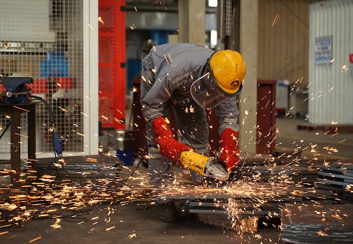 Fabricator grinding steel in the workshop