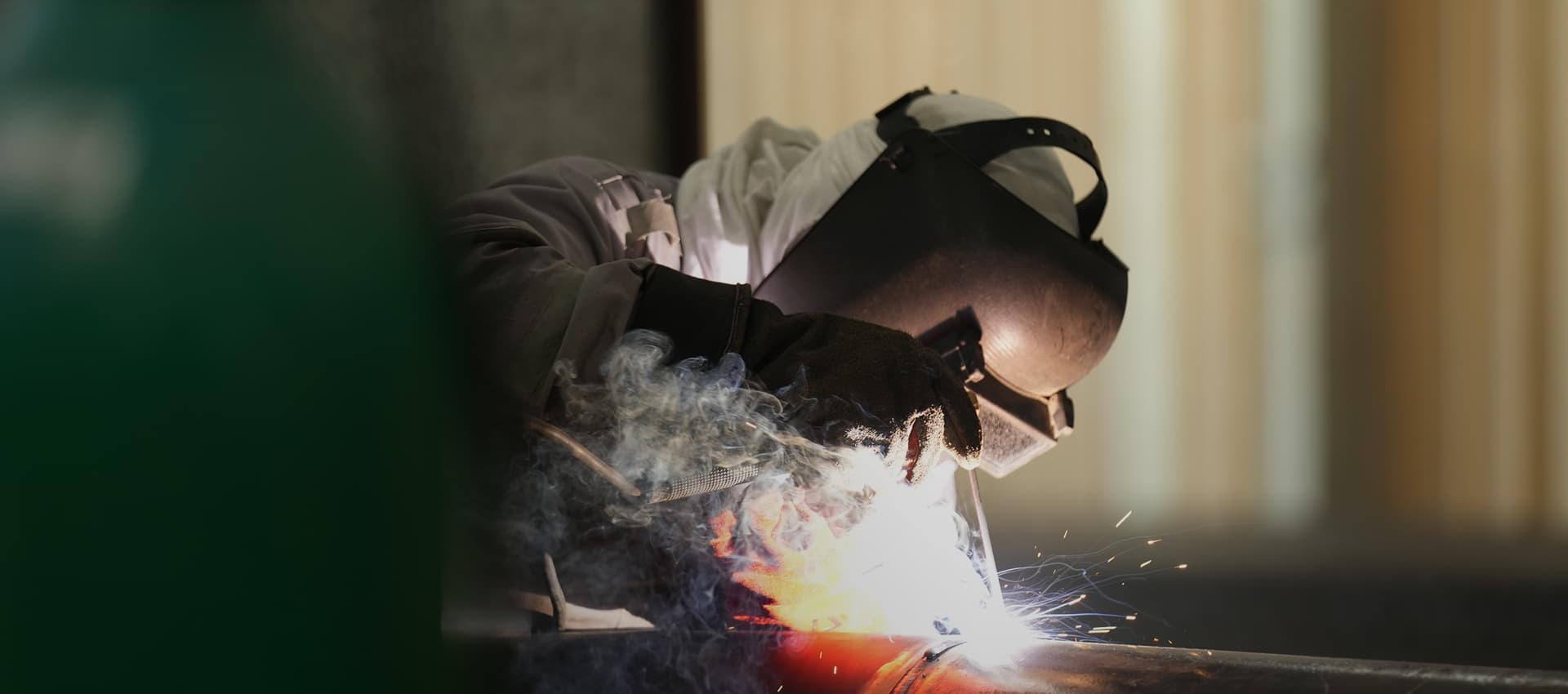 Welder joining a section of pipe inside the PESCO fabrication yard