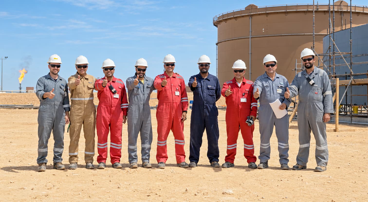 The PESCO site team giving a thumbs-up in front of a storage tank under construction