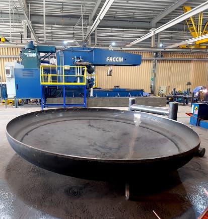 A formed dish end in front of the dishing machine