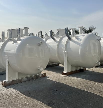 White horizontal storage tanks with saddles, finished outdoors