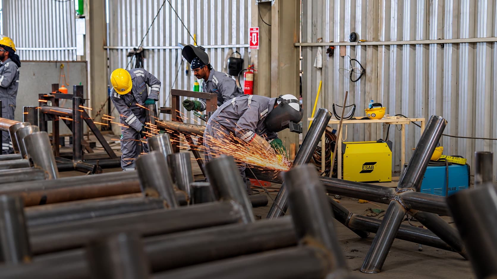 Prime Star technicians grinding and welding steel in the workshop